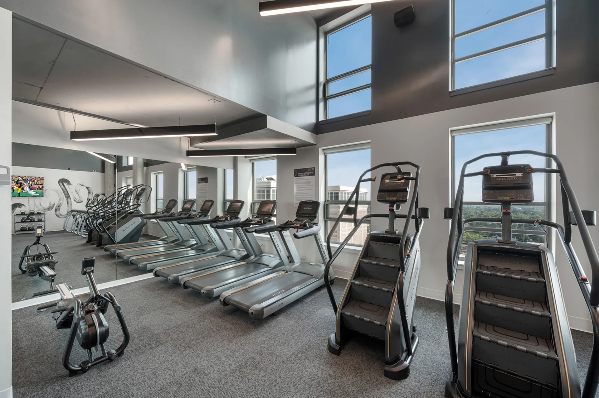 Modern gym with cardio equipment.