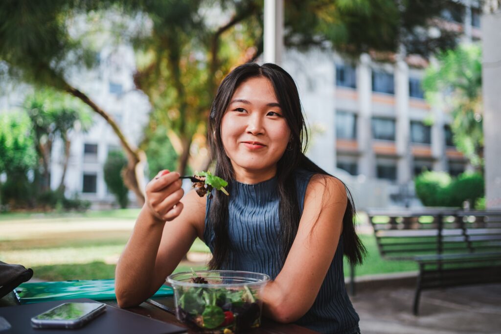 Young woman eating salad on an outdoor patio